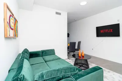 a living room with a green couch and a table at Luxury Studio Suite with King Bed Near Brickell & Marlins Park in Miami