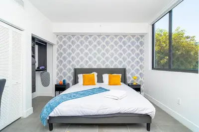 a bedroom with a bed with orange pillows and a window at Luxury Studio Suite with King Bed Near Brickell & Marlins Park in Miami