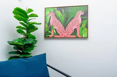 a picture of two parrots on a wall next to a plant at Modern 1BR Suite with King Bed Near Brickell, Downtown & Wynwood in Miami