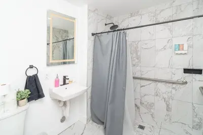 a white bathroom with a shower and a sink at Prime Miami Retreat with King Bed Near Brickell & Marlins Park in Miami