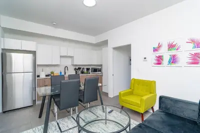 a living room with a table and a yellow chair at Miami City Escape 2BR Suite Near Brickell & The Beach Sleeps 6 Guests in Miami