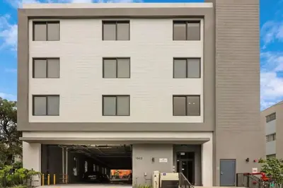 a large white building with a parking garage at Miami City Escape 2BR Suite Near Brickell & The Beach Sleeps 6 Guests in Miami