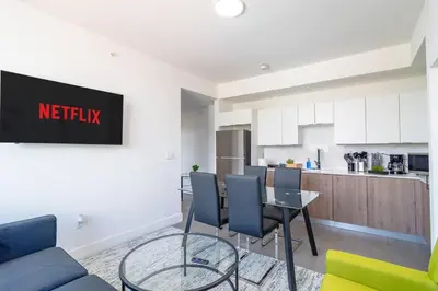 a living room with a table and a kitchen at Miami City Escape 2BR Suite Near Brickell & The Beach Sleeps 6 Guests in Miami