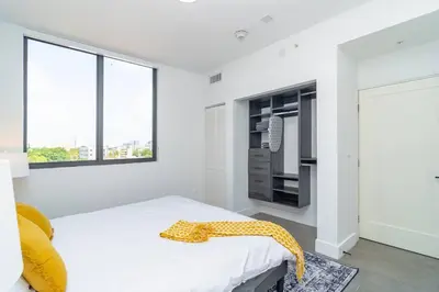 a white bedroom with a bed with a yellow blanket on it at Miami City Escape 2BR Suite Near Brickell & The Beach Sleeps 6 Guests in Miami