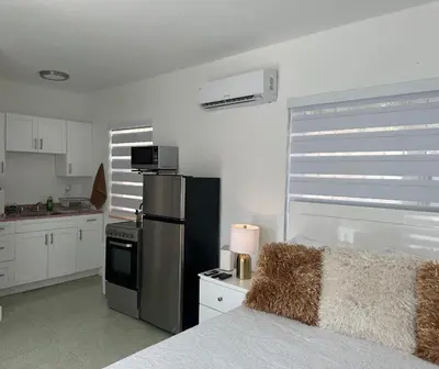 a kitchen with a stainless steel refrigerator and white cabinets at Villa Clara VIP-Little Havana in Miami
