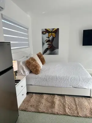 a white bedroom with a bed and a picture of a butterfly at Villa Clara VIP-Little Havana in Miami