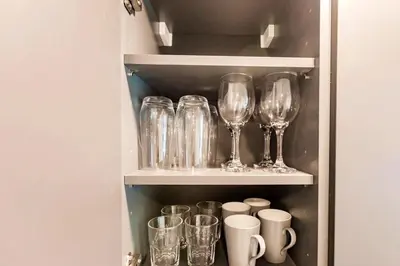 a row of glasses and cups on a shelf at Exclusive Condo w Beautiful City Views and Full Amenities! in Miami