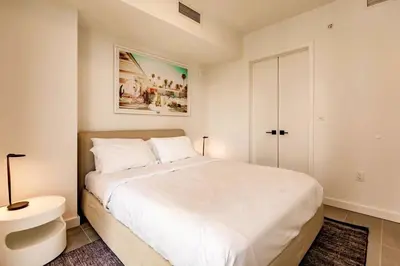 a white bedroom with a large bed and a sink at Exclusive Condo w Beautiful City Views and Full Amenities! in Miami