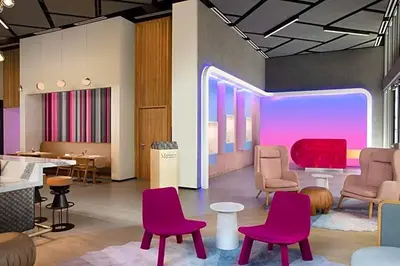 a waiting room with pink chairs and tables at Exclusive Condo w Beautiful City Views and Full Amenities! in Miami