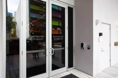 a glass door of a building with a reflection in it at Exclusive Condo w Beautiful City Views and Full Amenities! in Miami