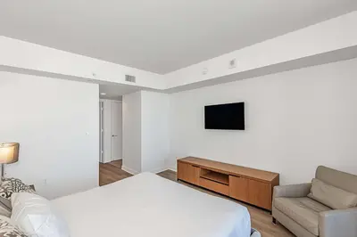a bedroom with a bed and a tv and a couch at Modern Resort with Amazing Pool in Hallandale Beach