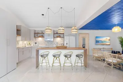a kitchen with a large island with four bar stools at Casa Santorini - Big Pool - Barbacoa - Fun and Relax in Miami