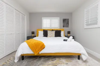 a bedroom with a large bed with a yellow headboard at Heated pool - 5min Coral Gables - Family Vacation in Miami