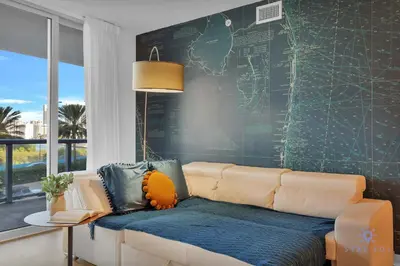 a living room with a couch and a map on the wall at Spectacular Near Beach - 2 BR Apartment in Hallandale Beach