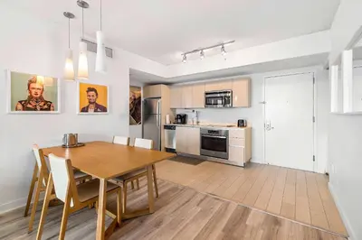 a kitchen and dining room with a wooden table at Top Luxury Apartment with Pool & Gym in Hallandale Beach