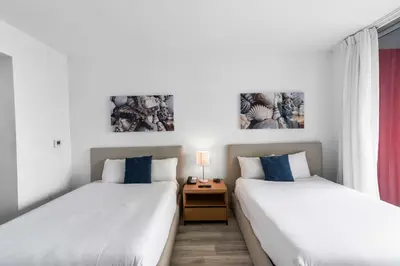 two beds sitting next to each other in a room at Modern New Studio Balcony & Pool in Hallandale Beach
