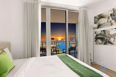 a bedroom with a bed and a view of the city at Modern 2BR 2BA Oasis & pool in Hallandale Beach