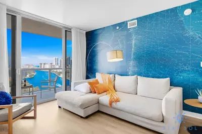 a living room with a white couch and a blue wall at Modern 2BR 2BA Oasis & pool in Hallandale Beach