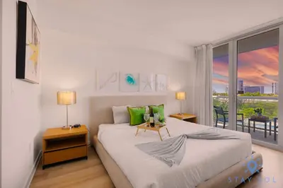 a bedroom with a bed and a large window at Modern Resort -Balcony Views & Pool in Hallandale Beach