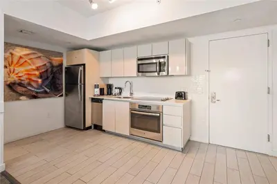 a kitchen with white cabinets and stainless steel appliances at 2 BR Apartment with Balcony Pool View and Near Beac in Hallandale Beach