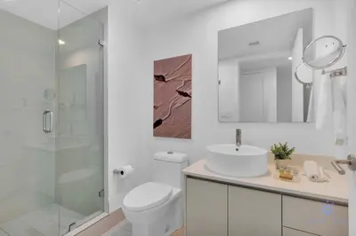 a bathroom with a toilet and a sink and a shower at 2 BR Apartment with Balcony Pool View and Near Beac in Hallandale Beach