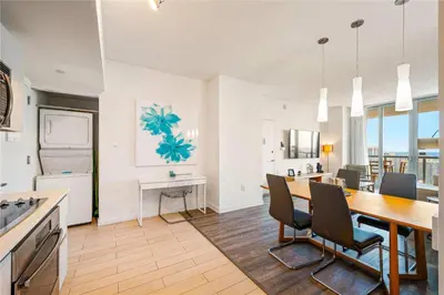 a kitchen and dining room with a table and chairs at 1 BR Apartment with Balcony Gym & Amazing Pool in Hallandale Beach