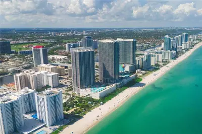 an aerial view of a beach with buildings and the ocean at 1 BR Apartment with Balcony Gym & Amazing Pool in Hallandale Beach