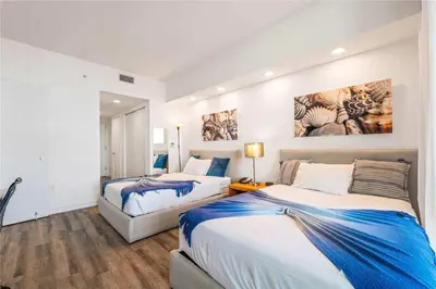a bedroom with two beds and a painting on the wall at Lovely Studio with Amazing View gym and amenities in Hallandale Beach