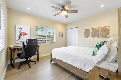 a bedroom with a bed and a desk and a chair at Coral Shores Waterfront Heated Pool Hosts 14! in Fort Lauderdale