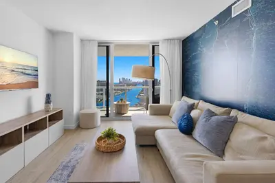a living room with a couch and a blue wall at Stylish Apartment 2BD 2BTH in Hallandale Beach