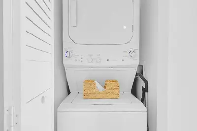 a washer and dryer with a basket on top of it at Stylish Apartment 2BD 2BTH in Hallandale Beach