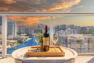a bottle of wine and two glasses on a table at Stylish Apartment 2BD 2BTH in Hallandale Beach