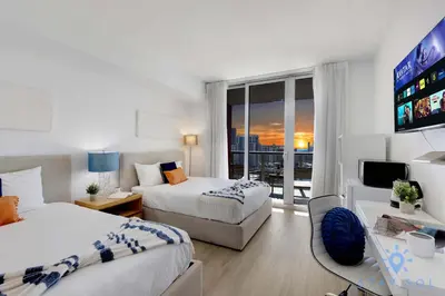 a hotel room with two beds and a television at Stylish Apartment 2BD 2BTH in Hallandale Beach