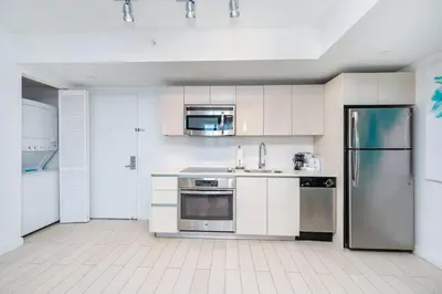 a kitchen with white cabinets and stainless steel appliances at 2 Bed & 2 Bath at Beachwalk With Pool Gym on 16fl in Hallandale Beach