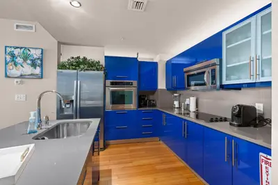 a kitchen with blue cabinets and stainless steel appliances at 2BR W Resort, Birds eye view of it all, Professionally Designed in Fort Lauderdale