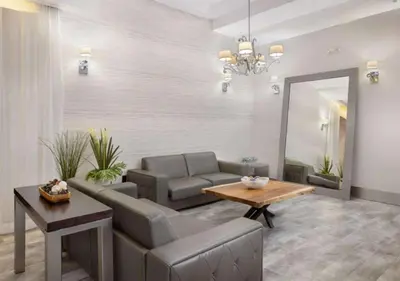 a living room with a couch and a table and a mirror at Art Deco Suite Steps from Beach in South of Fifth in Miami Beach