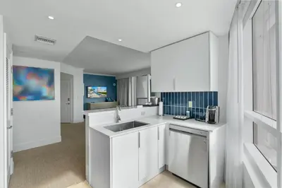 a kitchen with white cabinets and a sink at Fontainebleau Hotel One Bedroom Suite in Miami Beach