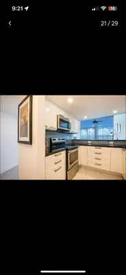 a kitchen with white cabinets and a large window at Luxury - Ocean front - Free Parking - 3 Bed 2 Bath in Miami Beach