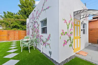 a garden with pink flowers on the side of a house at Cozy Casarita Cottage in Miami