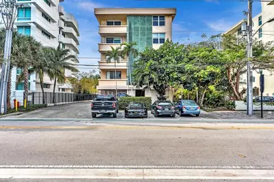 a group of cars parked in a parking lot in front of a building at Bay Harbor Sunset Apt 2A in Miami Beach