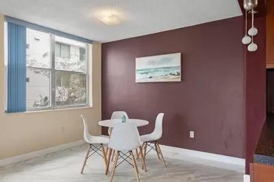 a dining room with a table and white chairs at Bay Harbor Sunset Apt 2A in Miami Beach