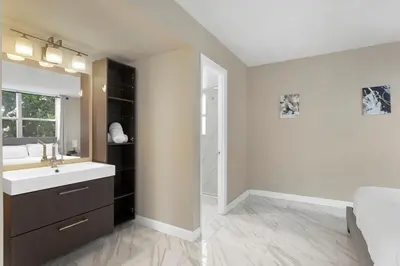 a bathroom with a sink and a mirror and a shower at Bay Harbor Sunset Apt 2A in Miami Beach