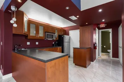 a kitchen with wooden cabinets and a black counter top at Bay Harbor Sunset Apt 2A in Miami Beach
