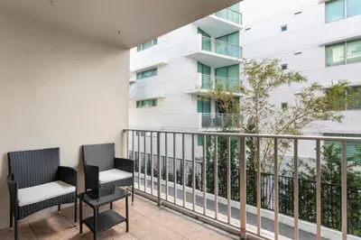 a balcony with two chairs and a building at Bay Harbor Sunset Apt 2B in Miami Beach