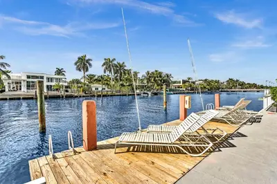 a group of chairs sitting on a dock next to the water at Bay Harbor Sunset Apt 2B in Miami Beach