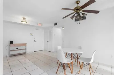 a dining room with a ceiling fan and a table at Bay Harbor Sunset Apt 2B in Miami Beach