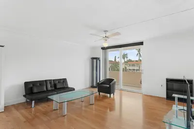 a living room with a black couch and a glass table at Bay Harbor Sunset Apt 2C in Miami Beach