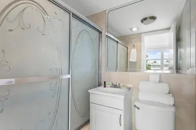 a bathroom with a shower and a toilet and a sink at Bay Harbor Sunset Apt 2C in Miami Beach