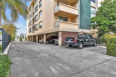 a truck parked in a parking lot in front of a building at Bay Harbor Sunset Apt 2C in Miami Beach