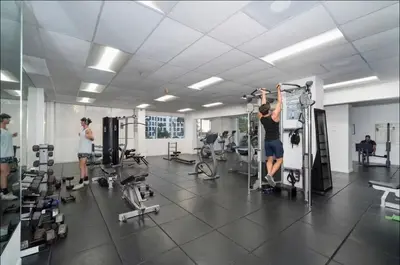 a man in a gym doing squats on a machine at Oceanfront Luxury Miami Escape Pool&Gym in Miami Beach